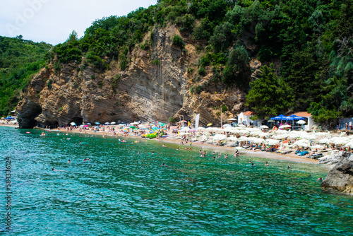 Sun loungers and umbrellas on the sandy Morgen beach located near the city of Budva. Montenegro.