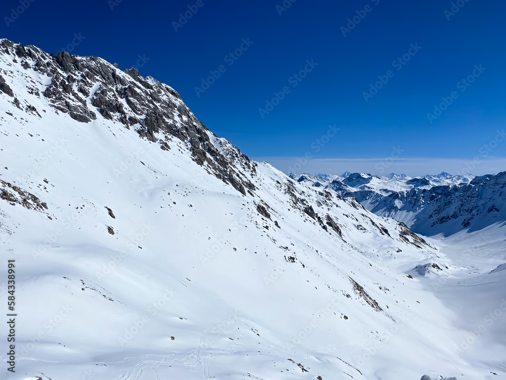Alpine valley, snowy mountains in Switzerland. Panoramic view over the mountains during winter. Ski area Arosa, Switzerland. Winter sports in the snowy mountains.