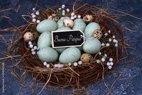 Konstfotografi Uova di Pasqua verdi pastello e uova di quaglia in un nido con la scritta Buona Pasqua su un'etichetta