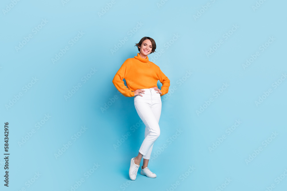 Full length photo of lovely young lady hands waist posing shopping banner dressed stylish orange garment isolated on blue color background