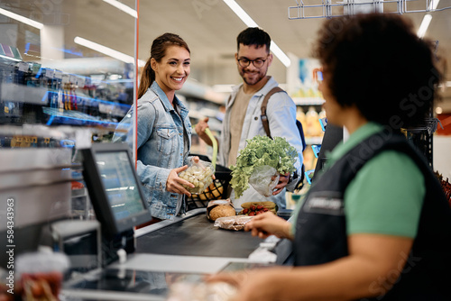 Young happy couple buying groceries in supermarket. photo