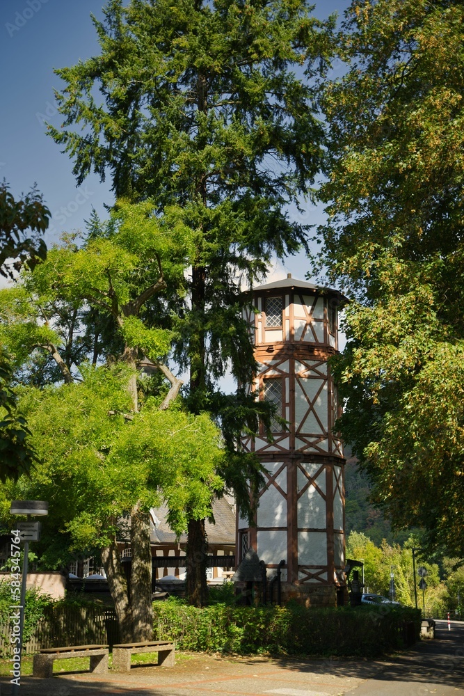 Vertical closeup shot of a wooden building surrounded by green trees on a sunny day Vertical closeup shot of a wooden building surrounded by green trees on a sunny day