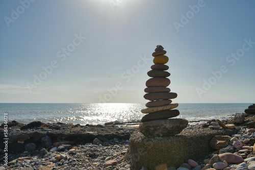 Pile of a balanced stone pyramid with a sea in a background