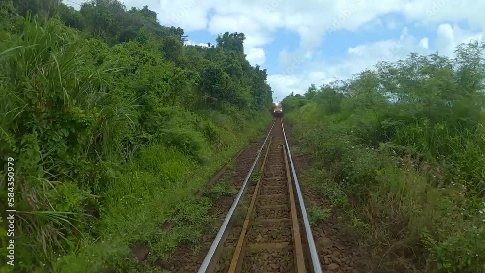 fpv drone circling around the train that rides along the sea