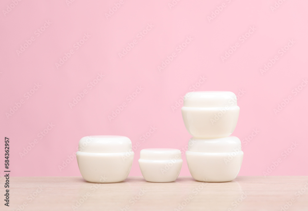 White cream jars on the table, pink background. Creative layout. Template for design. Beauty mockup White cream jars on the table, pink background. Creative layout. Template for design. Beauty mockup
