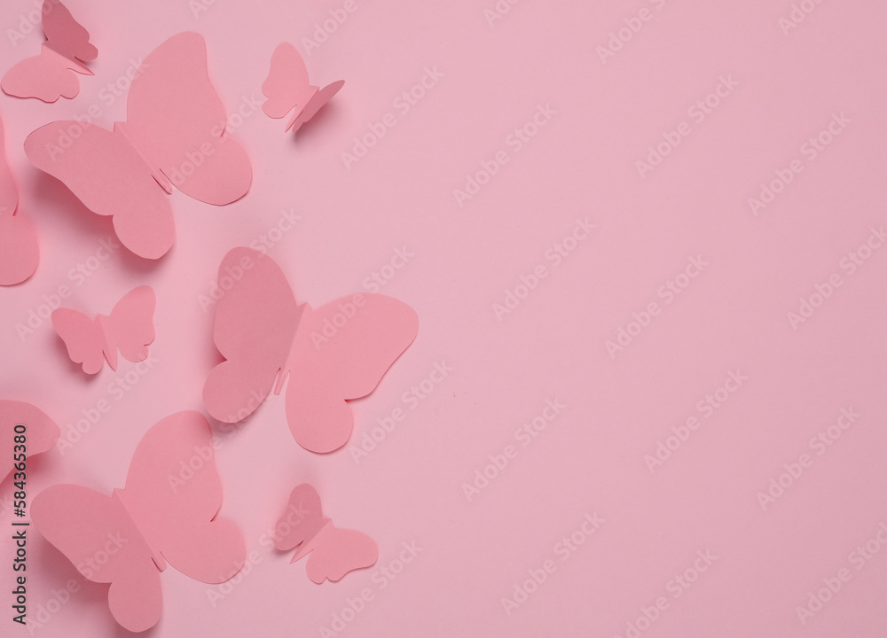Butterflies cut out of paper on a pink background. Spring background. Copy space