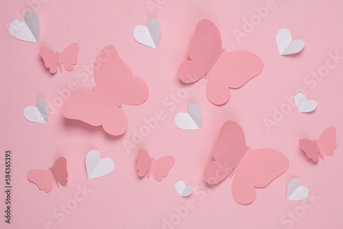 Butterflies and hearts cut out of paper on a pink background. Spring background, love concept. Creative layout