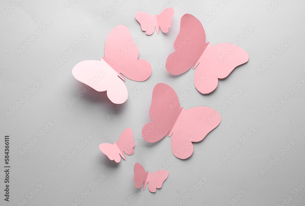 Obraz premium Butterflies cut out of paper on a gray background. Spring background
