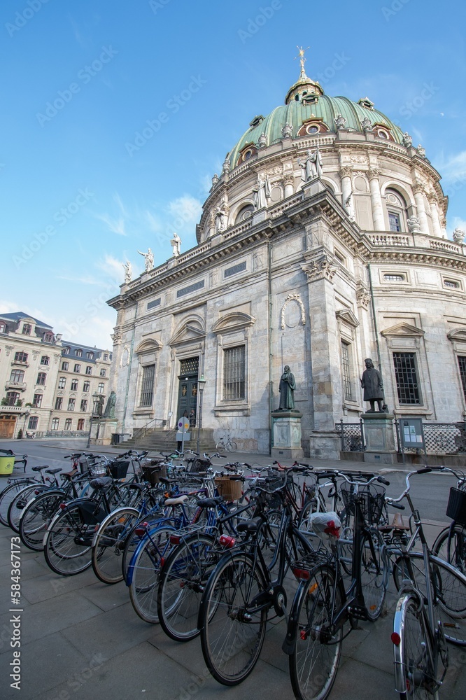 Naklejka premium Vertical shot of bikes near Frederik's Church in Copenhagen, Denmark