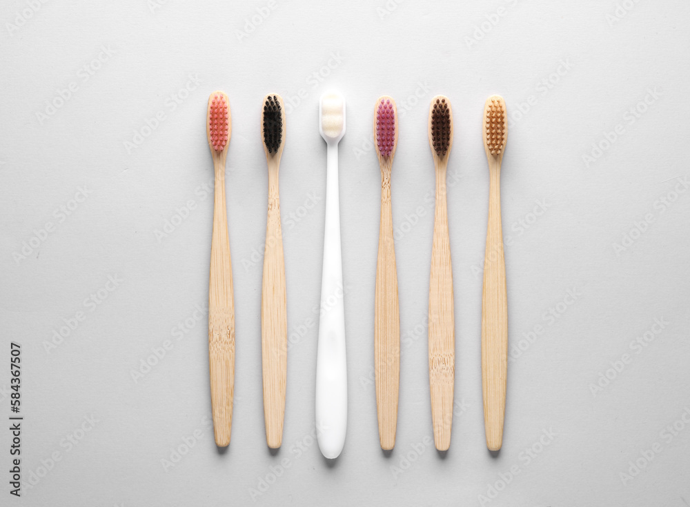 Plastic and wooden toothbrushes on gray background with circles. Eco concept. Top view. Plastic and wooden toothbrushes on gray background with circles. Eco concept. Top view.