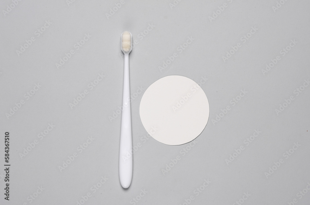 White toothbrush on gray background with circle. Top view. Copy space White toothbrush on gray background with circle. Top view. Copy space