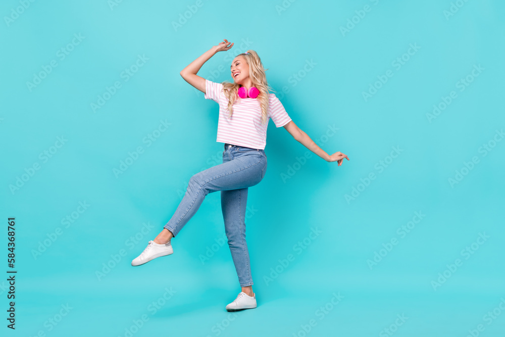 Full size photo of adorable cheerful woman wavy hairdo striped t-shirt dancing with headphones isolated on bright teal color background