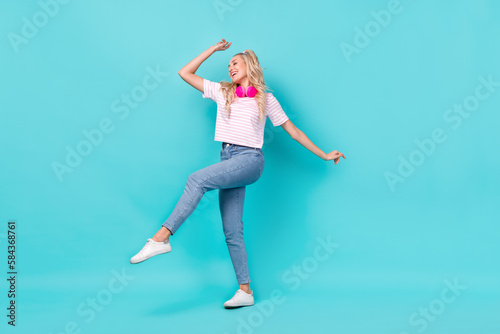 Fototapeta Naklejka Na Ścianę i Meble -  Full size photo of adorable cheerful woman wavy hairdo striped t-shirt dancing with headphones isolated on bright teal color background