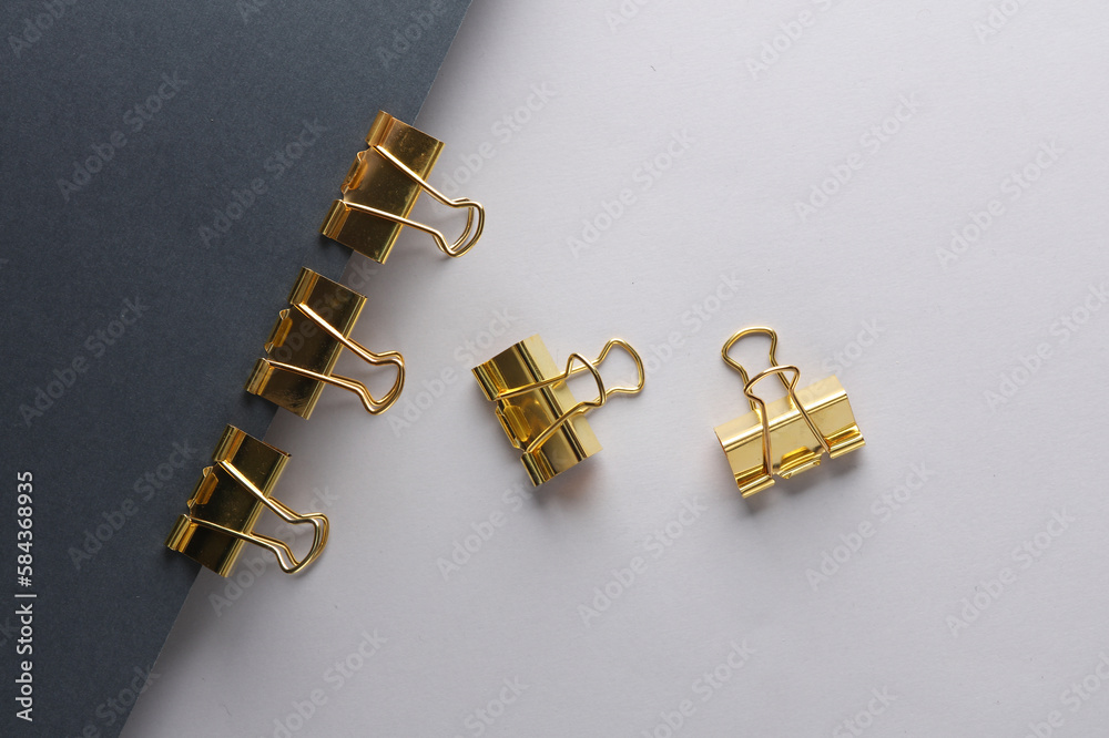 Golden binders on black and gray background. Creative layout. Minimalism composition. Top view