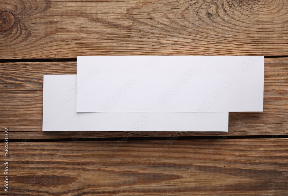 Mockup of two white blank tickets or flyers on wooden background. Template for design Mockup of two white blank tickets or flyers on wooden background. Template for design