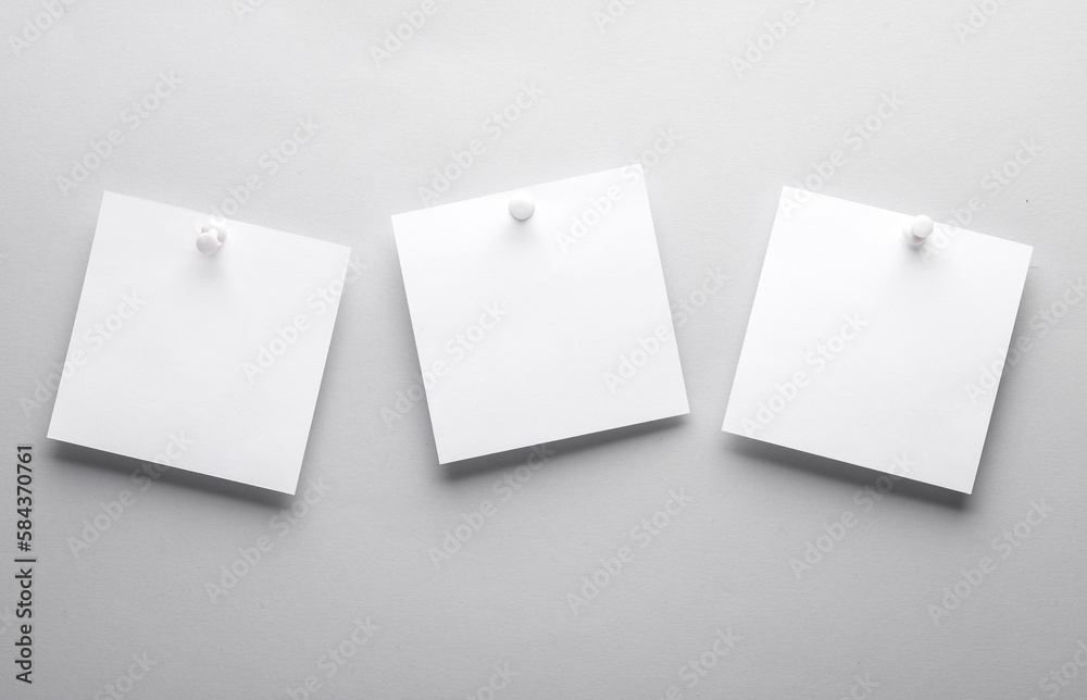 White empty square memo sheets of paper with pushpin on gray background. Template for design. White empty square memo sheets of paper with pushpin on gray background. Template for design.