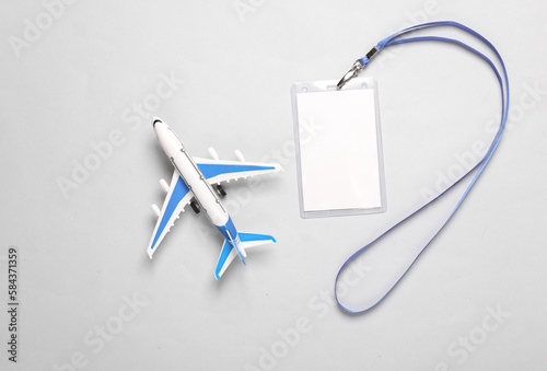 Toy air plane and empty white ID card badge mockup on gray background. Top view