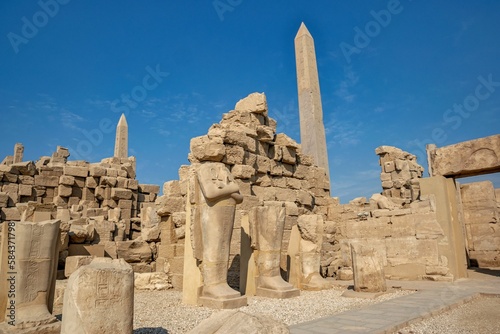 Tall statues by the Karnak temple on blue sky background in Luxor, Egypt