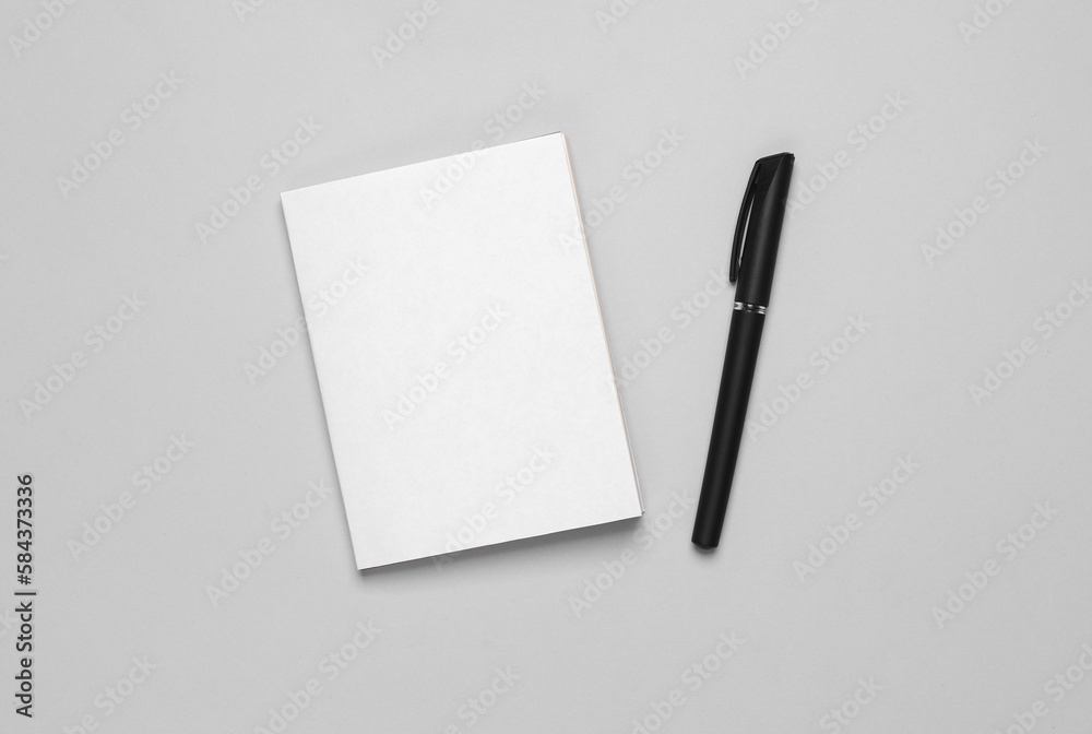 Book or notepad mockup with white cover, pen on gray background. Template for design Book or notepad mockup with white cover, pen on gray background. Template for design