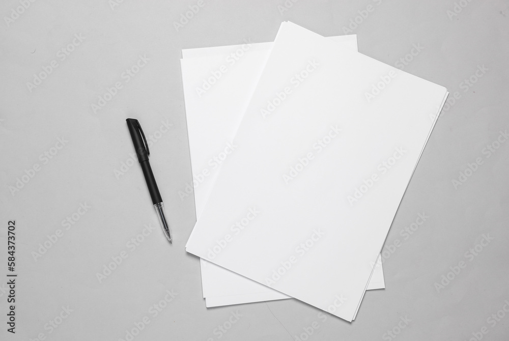 White blank sheets of a4 paper size or documents mockup with pen on a gray background. Template for design - obrazy, fototapety, plakaty 