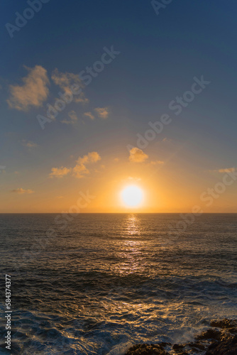 panorámica Impresionante puesta de sol desde los acantilados de la costa de Fuerteventura en un día de verano con cielo despejado y un gran sol bajo sobre el mar. Recursos naturales de Canarias © Safi