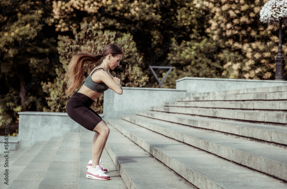 Young athletic woman practicing jumps up on the stairs. Outdoor training