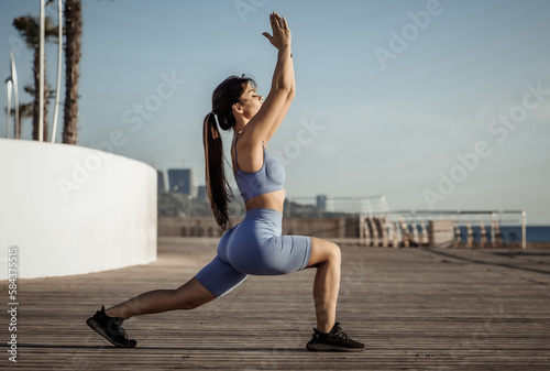 Young beautiful fit woman practicing yoga asana on the beach