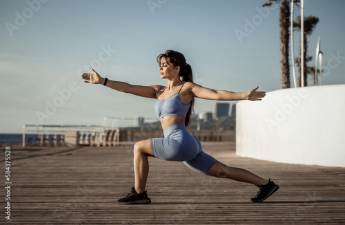 Young beautiful fit woman practicing yoga asana on the beach