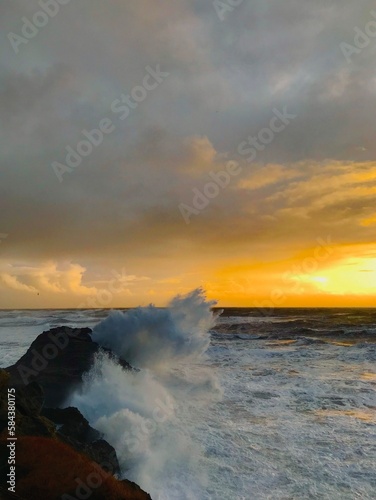 Obraz na płótnie Coucher de soleil sur l'océan avec vagues w salonie