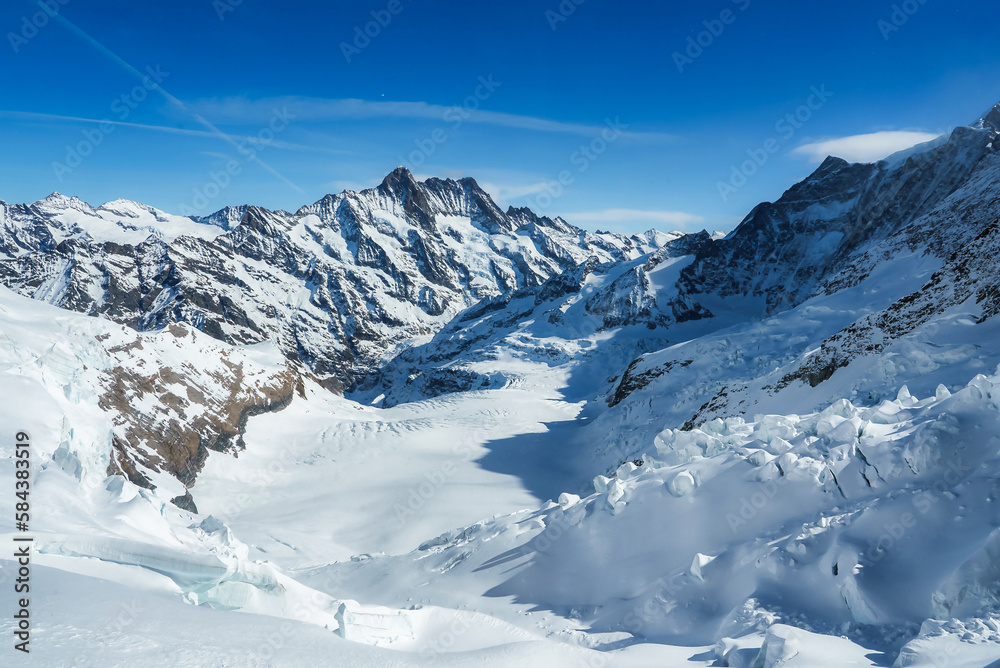 Fototapeta premium Magica view of the Alps mountains in Switzerland. View from helicopter in Swiss Alps. Mountain tops in snow. Breathtaking view of Jungfraujoch and the UNESCO World Heritage - the Aletsch Glacier