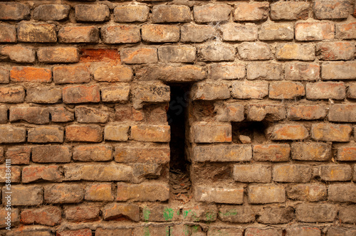 A brick wall with a cross-shaped hole in the middle