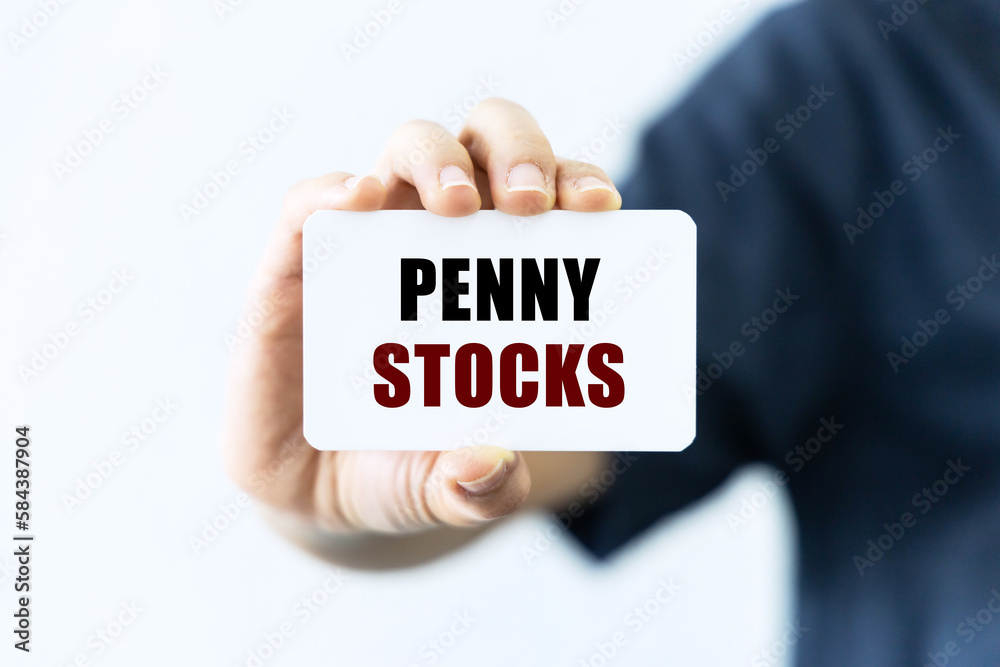 Penny stocks text on blank business card being held by a woman's hand with blurred background. Business concept about penny stocks. Penny stocks text on blank business card being held by a woman's hand with blurred background. Business concept about penny stocks.