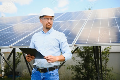 Engineer at solar power station with solar panel. Practical lessons on renewable energy power plants. © Serhii