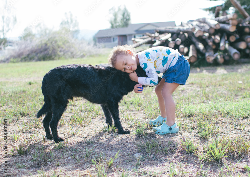 girl hugging a dog in the countryside in the summer