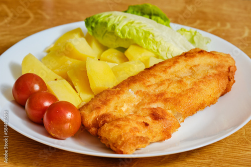 Fried fish with potatoes on plate