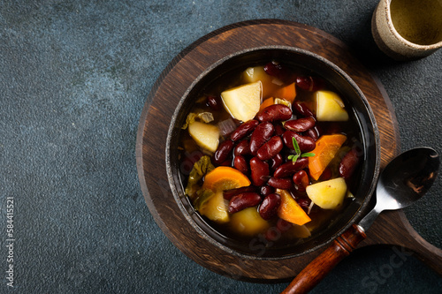 Homemade bean soup with ingredients. horizontal view from above. Ribolita. Vegetarian soup. Bean stew. Eintopf soup. Beans ragout.