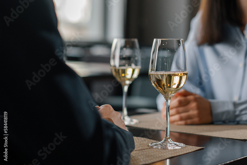 A date in a hotel restaurant a man and a woman drink white wine in glasses close-up