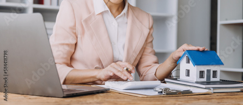 Real estate broker agent presenting and consult to customer to decision making sign insurance form agreement, buy and sell home model, concerning mortgage loan offer for and house insurance