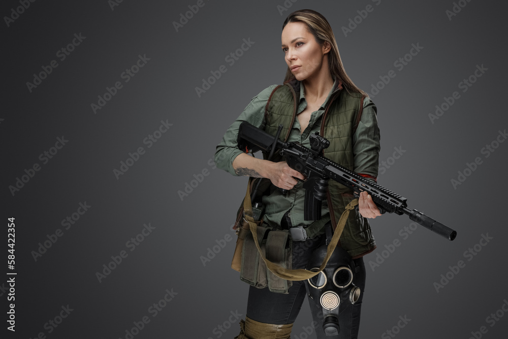 Studio shot of professional killer woman with rifle in setting of post apocalypse. Studio shot of professional killer woman with rifle in setting of post apocalypse.