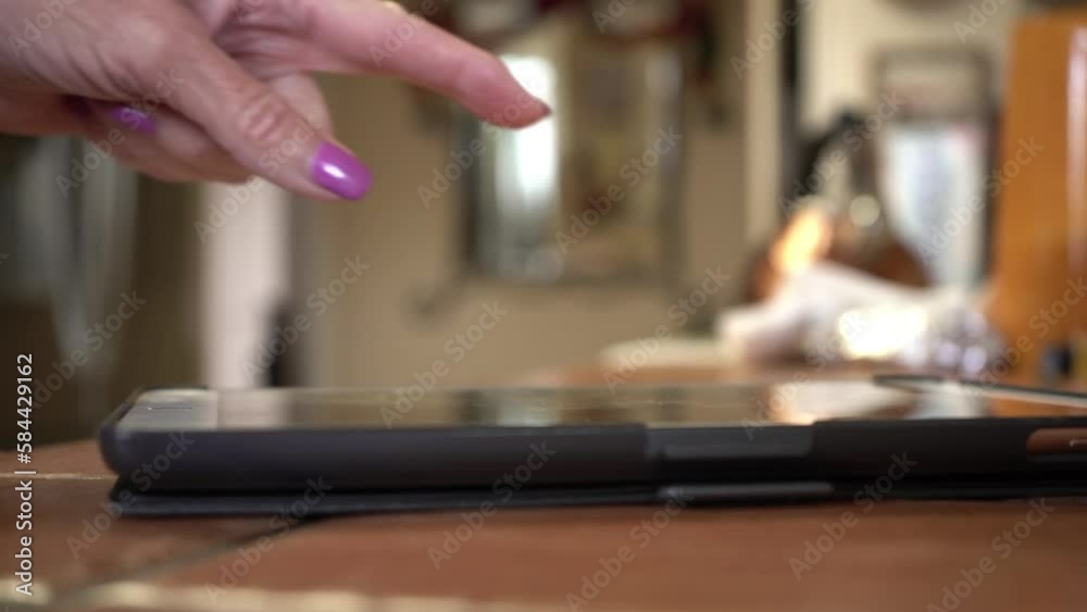 A mature woman using a tablet computer, close up