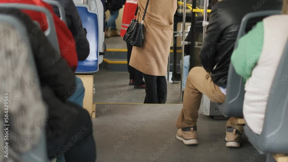 Unrecognizable passengers in the cabin of a bus or tram are sitting and moving around the cabin Unrecognizable passengers in the cabin of a bus or tram are sitting and moving around the cabin