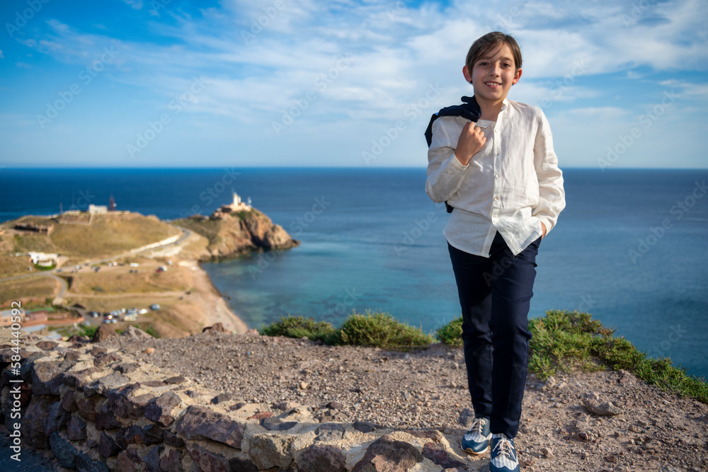 A Sunny Day on the Cliff: Portraits of the Smiling Boy with the Lighthouse in the Background