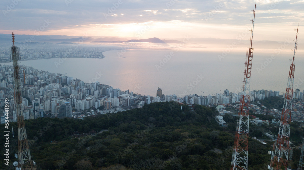 Fototapeta premium Paisagem Urbana Cidade Florianopolis Centro Trindade Itacorubi Beira Ilha Mar Baía Norte Morro da Cruz Prédios Arquitetura Engenharia Urbanismo Santa Catarina Por do Sol Drone Aérea 