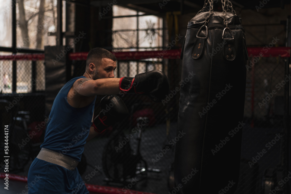 Boxing gym a boxer trains his punches hitting a punching bag