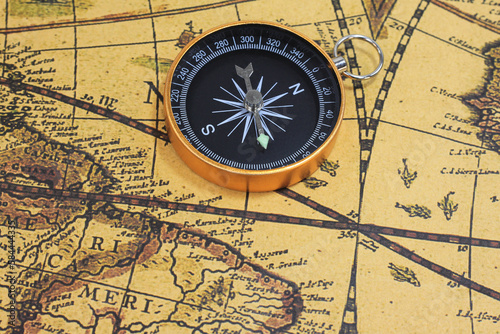 Classic round compass on background of old vintage map © yarbeer