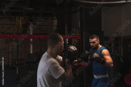 Boxer Practices His Punches with His Coach in the Boxing Gym