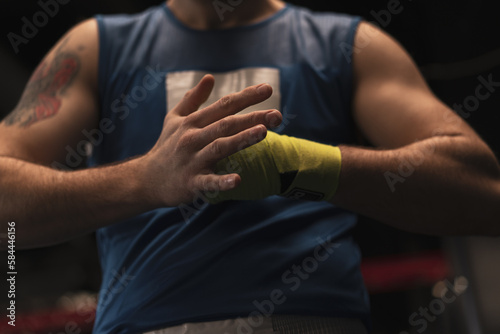 Male boxer wraps his arms before a fight Young sportsman prepares for a fight close-up Sports concept