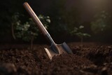  a shovel and a shovel stuck in the ground in the dirt with a tree in the background in the evening light of a street light.  generative ai