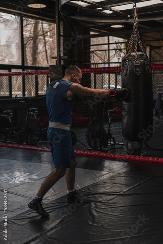 Boxing gym a boxer trains his punches hitting a punching bag © Guys Who Shoot