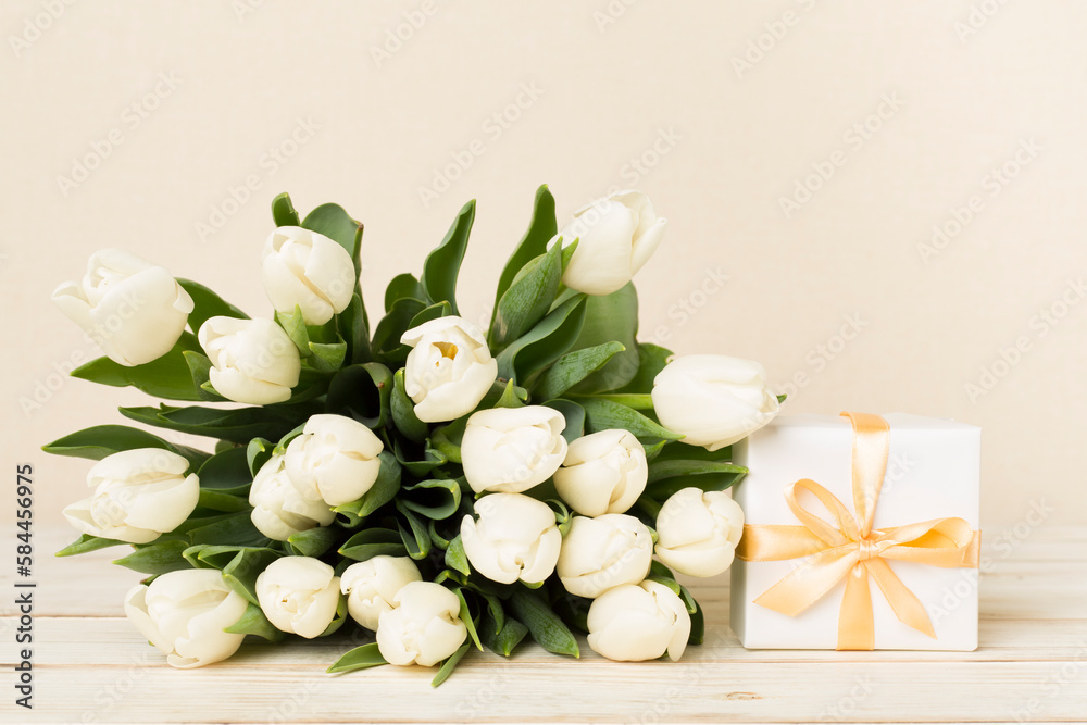 White tulip bouquet with gift box on table White tulip bouquet with gift box on table